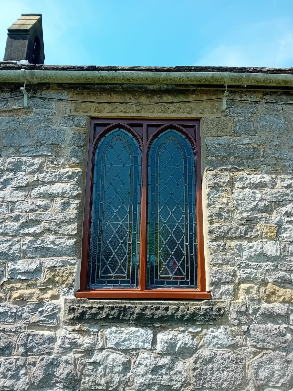 St Hughes Church Foolow — restored gothic window with new oak frame in stone wall