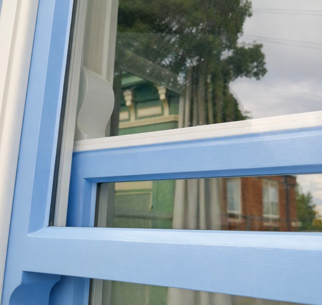 Close-up of blue sash window frame showing draught seal detail